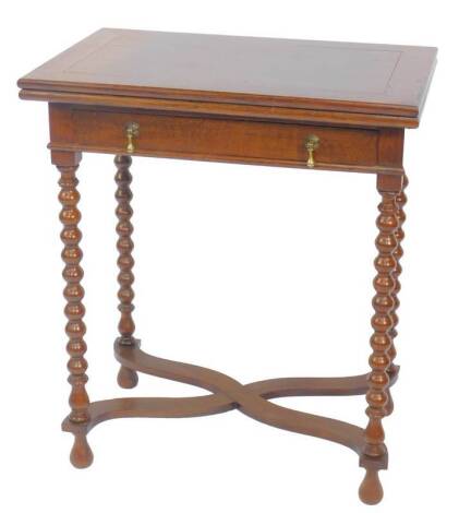 A 17thC style oak fold over card table, with a single frieze drawer raised on bobbin turned supports united by an x-frame stretcher, 69cm H, 61cm W, 40cm D.