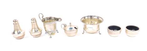 A George V silver cream jug and sugar bowl, with gadrooned rims, raised on pad feet, Birmingham 1913, and a George V silver four piece condiment set, with engine turned decoration, Birmingham 1913, 8.18oz all in.