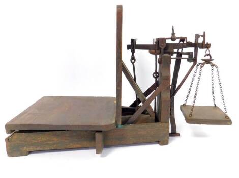 A set of 19thC rustic cast iron and pine weighing scales, 70cm W.