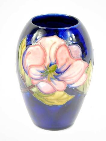 A William Moorcroft baluster vase, blue ground and tube lined with anemones, impressed mark to base Moorcroft Made in England, 14cm H.