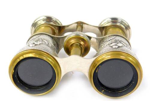 A pair of 19thC French embossed white metal opera glasses, with brass framing and decorated grips with exotic birds berries and foliage, 9cm when extended.