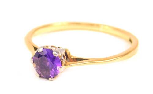 An amethyst solitaire ring, with round brilliant cut amethyst 4.8mm x 2.6mm, in a raised claw setting, with pierced V shaped shoulders, yellow metal, marked 18ct and plat, ring size M, 1.7g all in.
