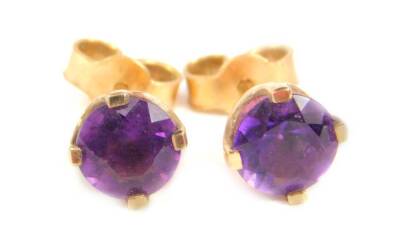 A pair of amethyst stud earrings, each stone round brilliant cut, in claw setting, with enclosed back, with butterfly backs, yellow metal, unmarked, possibly 18ct, each earring head 6mm wide, 1.3g all in.