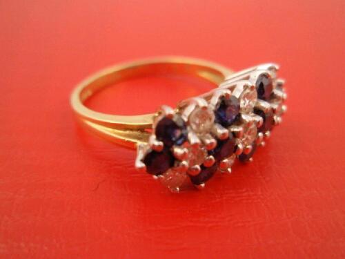 A ladies dress ring of alternate diagonal rows of small diamonds and sapphires