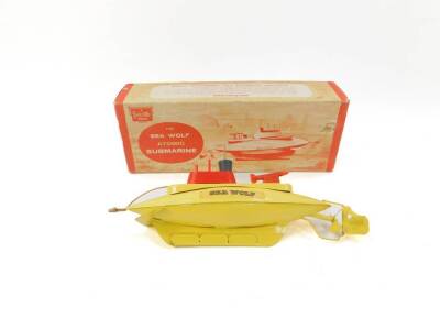A Sutcliffe model of The Sea Wolf atomic submarine, being a yellow tinplate model with clockwork mechanism to enable dive and surface action, together with original box and winding key.