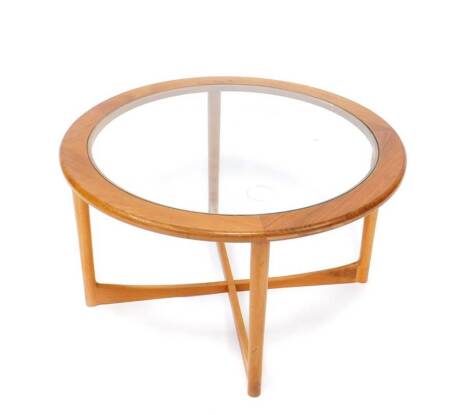 A late 20thC Nathan teak circular occasional table, with glass inset top, raised on turned legs, united by an H framed stretcher, 45cm H, 80cm D.