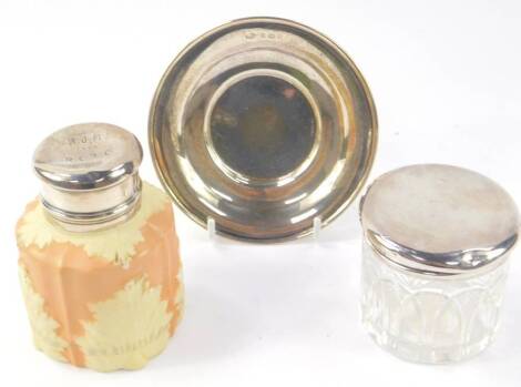 A George V cut glass toilet jar with silver lid, Birmingham 1931, Edward VII silver dish or card salver, Birmingham 1905, and a Locke & Company Worcester porcelain jar, moulded with acanthus leaves against a salmon pink ground, with silver lid, presentati