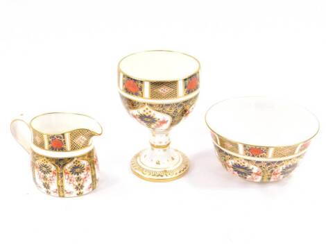 A Royal Crown Derby Imari porcelain goblet, pattern no 1128, 12cm H, together with a cream jug and sugar bowl. (3)