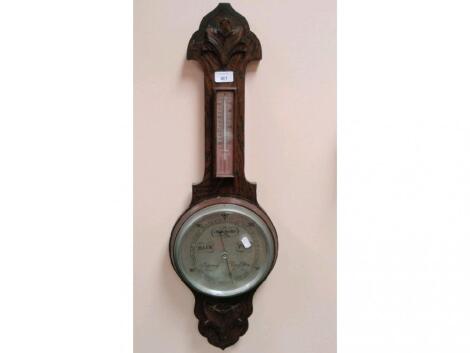 A 1930's carved oak aneroid wheel barometer