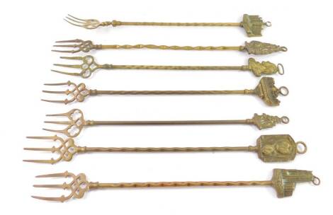 Seven brass toasting forks, some of local interest, including Burghley House, The Bridge St Ives Huntingdon, Spalding, and Cromer Church.