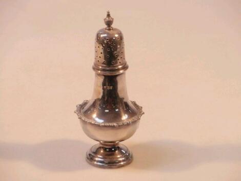 A silver sugar caster with gadroon border