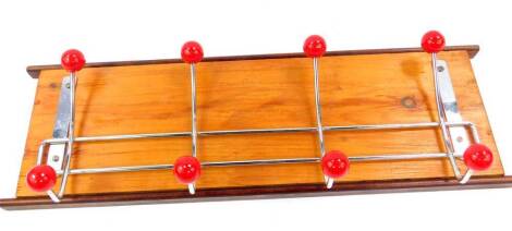 A pine oak and metal atomic coat rack, with eight red balls, 15,5cm H, 49.5cm W.