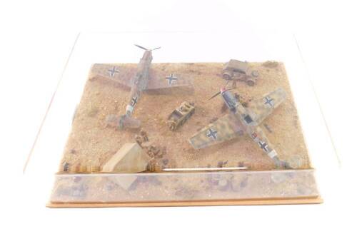 A WWII German Model Aircraft Tableau, North Africa Campaign, containing two Messerschmitt BF109s, desert camouflage, vehicles and figures, 42cm x 32cm.