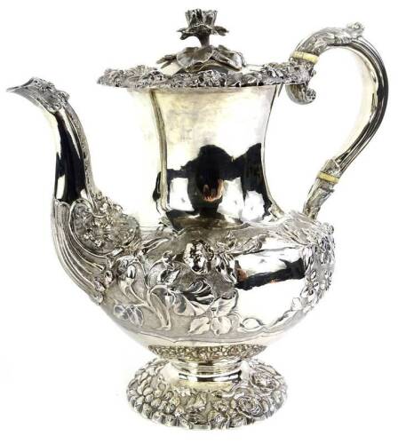 An early Victorian silver coffee pot, with embossed and repousse decoration of roses, other flowers, leaves etc., the hinged lid with a flower knop, the scroll handle with ivory insulators, London 1841, makers stamped WR, possibly for William Richards, 33