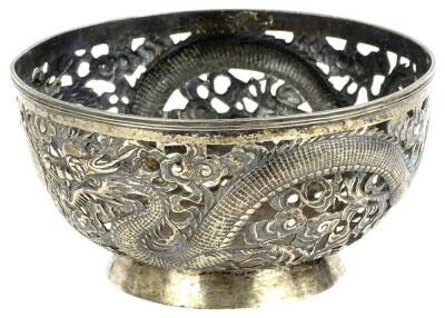 A Chinese white metal bowl, with pierced decoration cast with dragons etc., signed to underside and numbered 90, 17oz, 19cm dia.