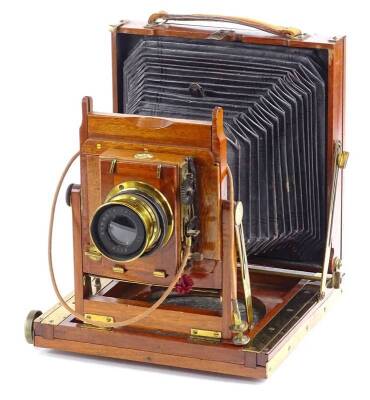 A Thornton Pickard mahogany and brass plate camera, with canvas bellows, the lens stamped Beck Symmetrical, 26cm L when opened.