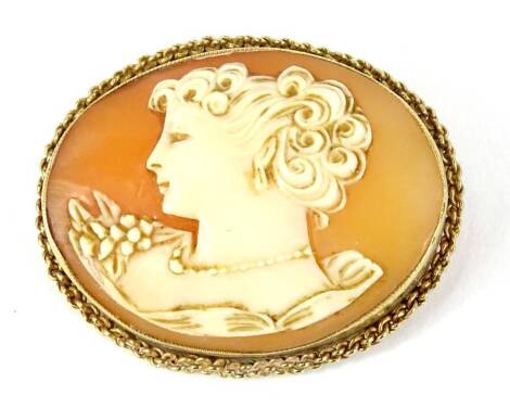 A shell cameo brooch, of maiden head and shoulders, of oval form, in yellow metal frame, with twist design borders, unmarked, 4.5cm W, 9.4g all in. Provenance: The property of Joan Stephenson, Kirkwood, North Church Walk, Newark, Nottinghamshire.