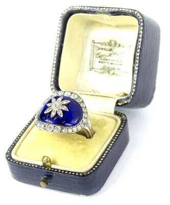 A late 19thC/early 20thC dress ring in George III style, with central oval blue enamel panel set with central floral design and paste set flower and borders, silver plated, ring size S½.