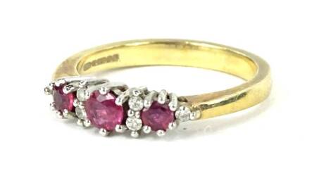 A 9ct gold dress ring, set with three garnets and tiny white stones, each in claw setting, ring size L, 2.9g all in, boxed.