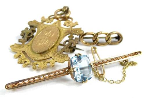 Three items of jewellery and trinkets, to include a chain bar brooch, with three links, yellow metal, unmarked, 1.1g, a 9ct gold fob or brooch, 6.4g all in, and an aquamarine set bar brooch, with pierced and scroll design bar and safety chain, 6cm long,