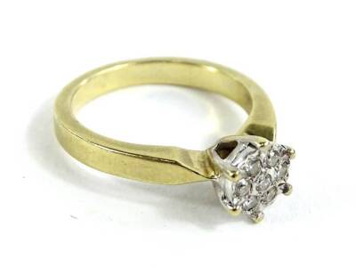 A 9ct gold dress ring, in the form of a flower and set with round brilliant cut diamonds, totalling approx 0.10cts and marked to inner band, ring size K½, 3.4g all in.