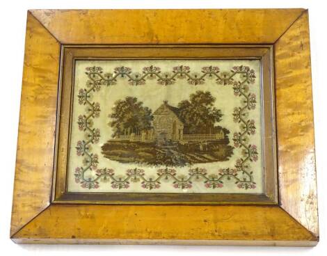 A 19thC embroidered picture, decorated with a church, trees, figures etc, within a floral border, in contemporary maple frame, 36cm x 44cm. Provenance: The property of Joan Stephenson, Kirkwood, North Church Walk, Newark, Nottinghamshire.