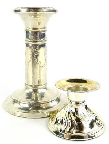 Two loaded silver candlesticks, to include an example decorated with Adam style swags, bows etc., Birmingham 1904 and a more modern dwarf candlestick.