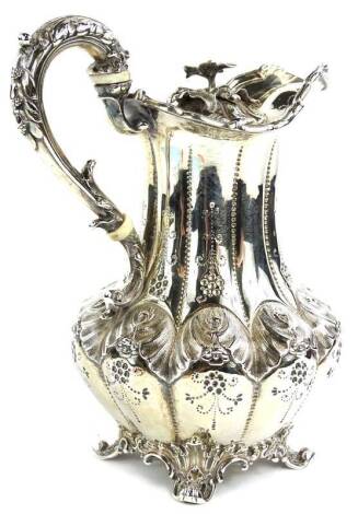 A late William IV silver hot water jug, with shaped sides, engraved with flowers etc., the scrolling handle cast with leaves and with ivory insulators, on leaf cast feet, London 1837 by Edward, Edward Junior, John & William Barnard, 11¾oz gross, 18cm H.