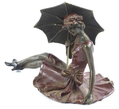 A cold painted erotic bronze figure of a girl with a parasol, in a seated position, stamped to underside, 11cm L.