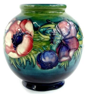 A Moorcroft pottery globular vase, decorated with a band of anemones on a navy and green ground, with impressed and hand written marks to underside (AF), 16cm H.