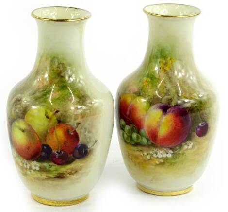 A pair of Royal Worcester small porcelain vases, each painted with fruit by Rickells, printed mark in puce to underside, 12cm H.