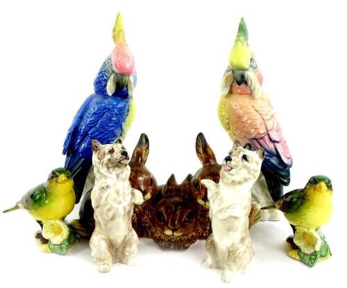 A collection of ceramic animals, to include two Karl Ens parrots, a Goebel group of three rabbits, two Royal Doulton terriers and a pair of Beswick Greenfinches (7).