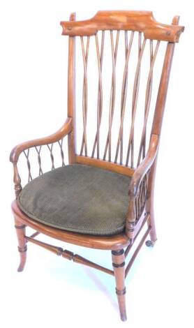 An Arts and Crafts satin birch and mahogany Windsor armchair, with a interwoven spindles, a cane seat on turned splayed legs.