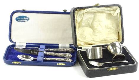 A George VI harlequin silver christening set, comprising egg cup, 5cm H, napkin ring and spoon, Birmingham 1938, 2oz, cased, further cased knife, fork and spoon set (2).