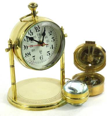 A collection of brass items, to include a compass and clock on a swivel with circular base, 20cm H, an Indian brass compass and a small reproduction railway regulator with magnifying glass.