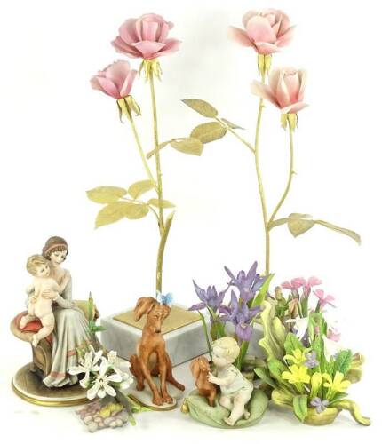 A quantity of Capodimonte and similar items, to include a figure group of a lady with a baby, a seated dog, a child with dog, a pair of gilt metal and porcelain roses, each mounted on a marble base and three botanical porcelain specimens, stamped Connoiss