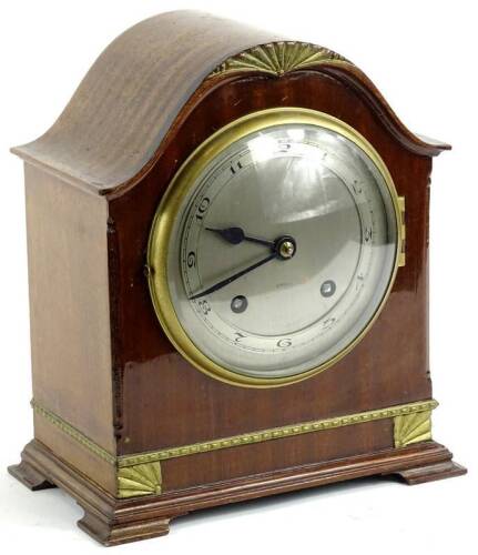 A mid 20thC walnut cased mantel clock, with 13cm dia Arabic dial, revealing an eight day key wind movement in a domed case on compressed bracket feet.