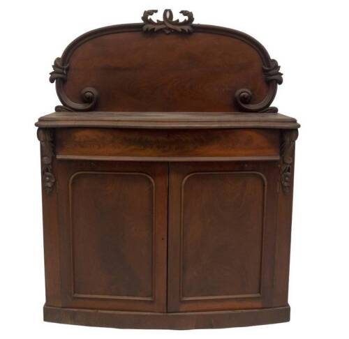 A Victorian mahogany chiffonier, with scroll carved and flamed back, serpentine moulded top, bowfront frieze drawer over two arch panel doors and plinth, 93cm H, 116cm W, 40cm D.