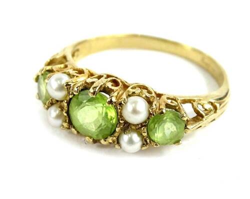 A 9ct gold gypsy ring, set with three peridot stones and four seed pearls, in scroll design ring head, ring size O, 2.9g all in.