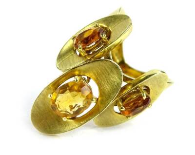 A modern dress ring, set with three ovals each with topaz stone, on yellow metal band, marked 750, ring size M, with wave design ring band, 8.1g all in.