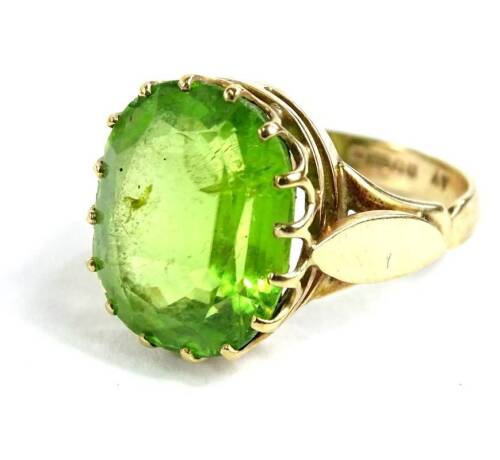 A 9ct gold peridot dress ring, with oval cut peridot, in raised claw setting, with V shaped shoulders, ring size P, 6.2g all in.