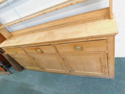 A Victorian pine dresser, the raised back with a moulded cornice above three shelves for plates, the base with three frieze drawers above three panel doors, each with brass handles, on plinth, 232cm H, 218cm W, 41cm D. Provenance: The property of Joan Ste - 2