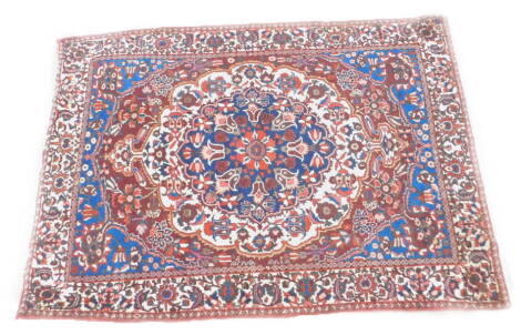 A Persian carpet, with an all over design of flowers, on a red ground with multiple borders, 314cm x 218cm.