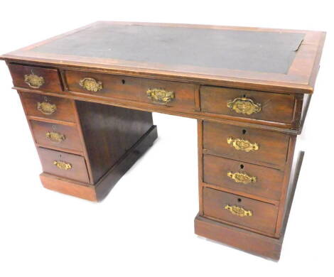 A late Victorian walnut pedestal desk, the top with a black leatherette inset above an arrangement of nine drawers, on a plinth with castors (AF), 125cm W.