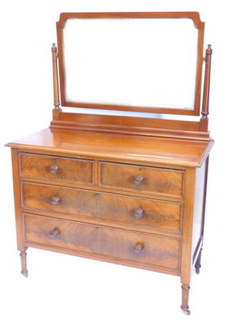 A late 19th/early 20thC mahogany dressing table, the rectangular bevelled mirror plate on turned supports, the base with two short two long drawers, with turned wood handles on turned tapering legs, 105cm W.