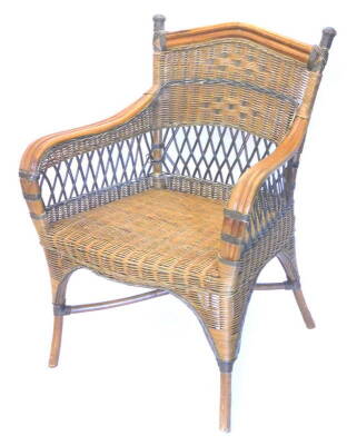 A caned conservatory chair, with shaped arms and an apron.