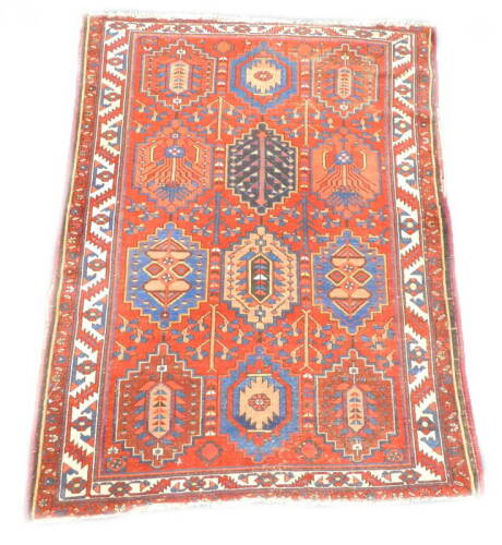 A Persian rug, with a design of twelve multi coloured medallions on a red ground with one wide border, 202cm x 150cm. Provenance: The property of Joan Stephenson, Kirkwood, North Church Walk, Newark, Nottinghamshire.