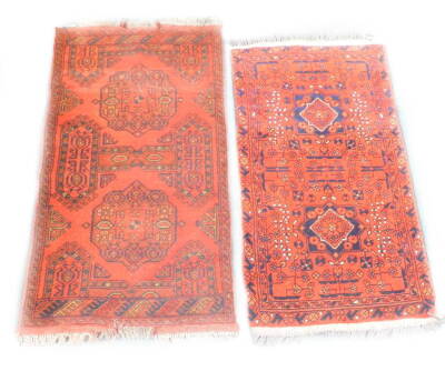 Two Turkish design small rugs, each with a design of medallions on a red ground, 94cm x 54cm and 100cm x 57cm respectively.