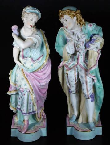 A pair of continental bisque porcelain figures of a lady and gentleman, each dressed in floral finery, predominately in turquoise, pink and blue, with gilt highlights, on shaped bases, unmarked, 46cm H. (2)