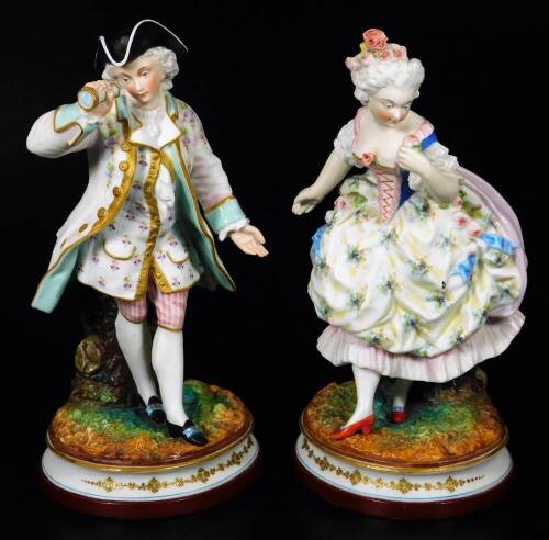 A pair of continental bisque porcelain figures, of a lady and gentleman, each dressed in finery, on naturalistic inverted circular bases with gilt highlights, polychrome decorated predominately in turquoise, pink and black, with further gilt highlights, L